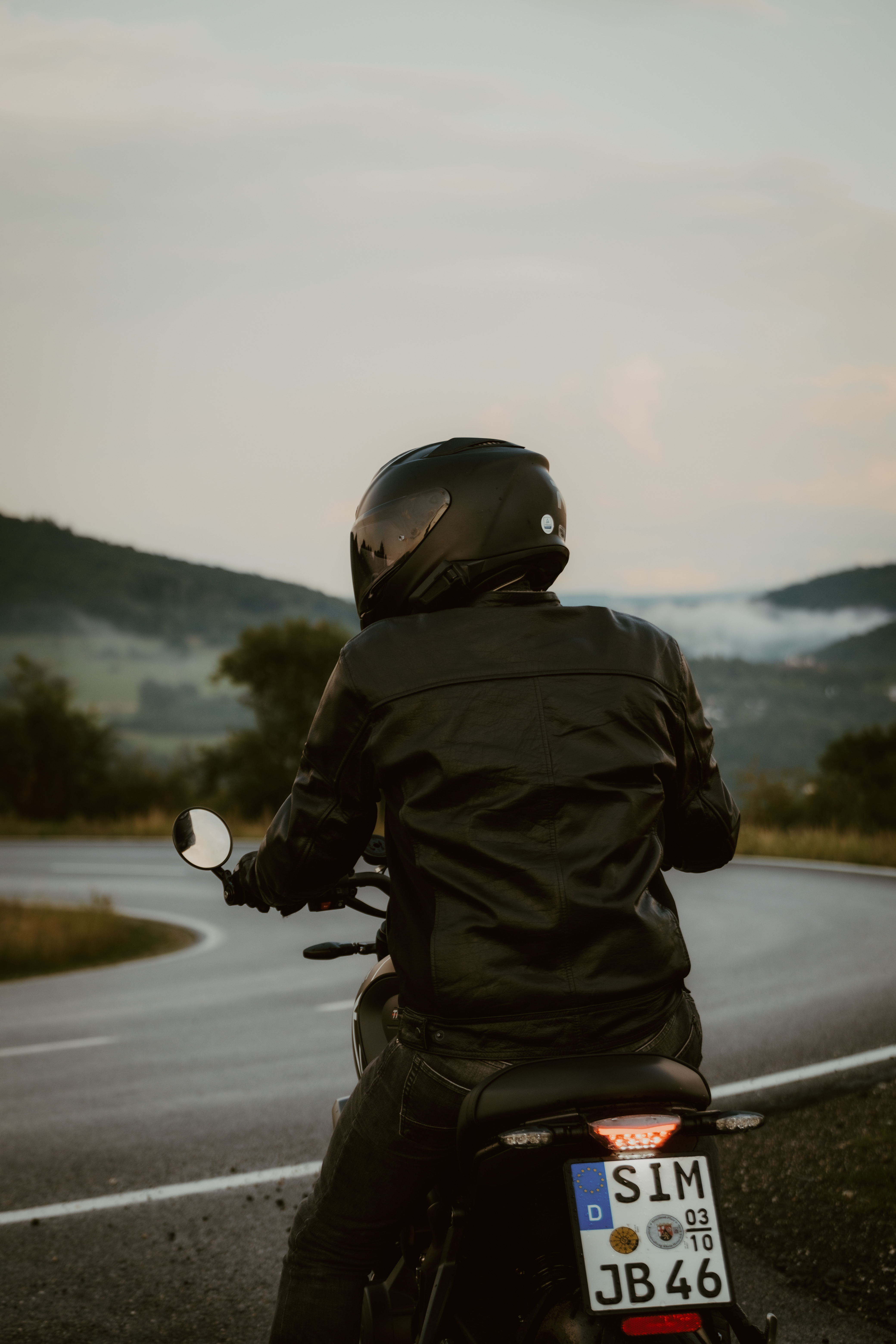 Blick nach vorn – Fahrer sitzt am Motorrad und schaut in die Ferne